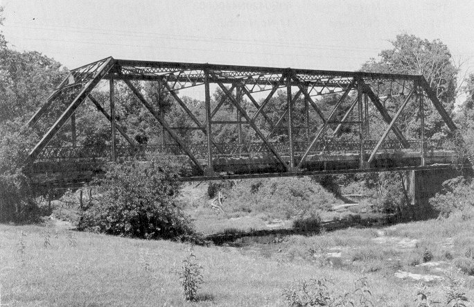 Bridge 07E2080N3830005 is modified Pratt through truss that spans Caddo Creek, three miles east of Bokchito in Bryan County.