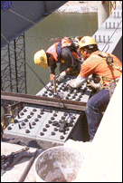 Workers Aligning Bolt Holes on Steel Beam
